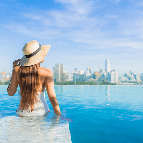 portrait-beautiful-young-asian-woman-relaxing-around-outdoor-swimming-pool-with-city-view (1)